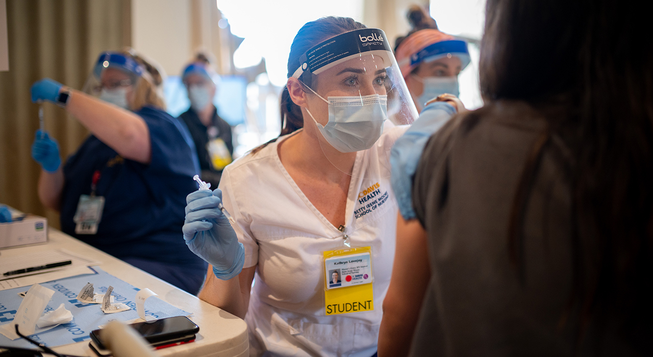 Student Kathryn Lovejoy gives a vaccine